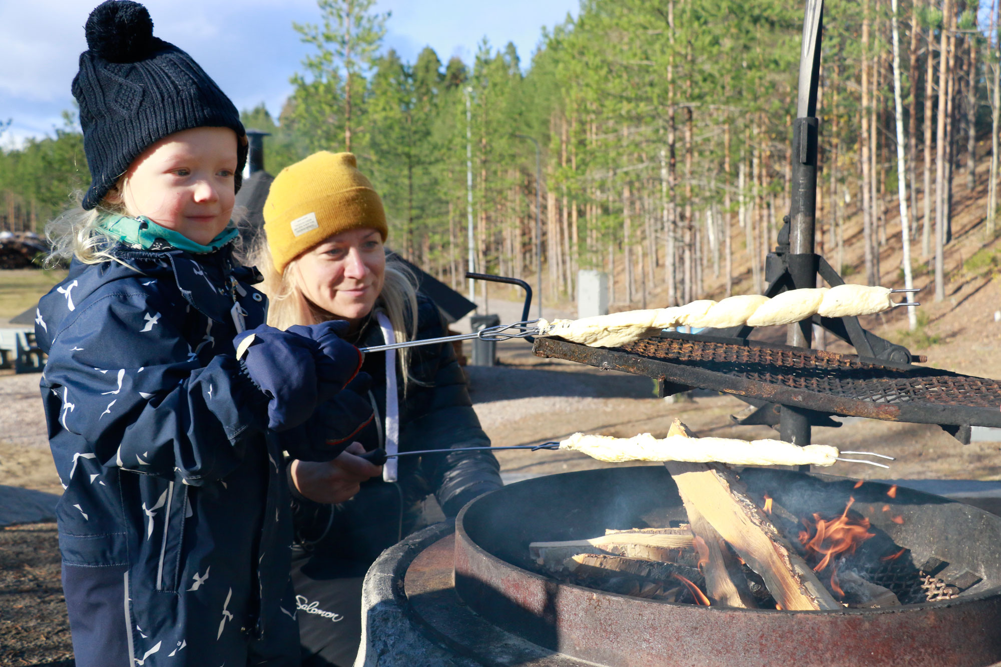 Huutijärvellä asuva Salla Tanhuanpää neuvoi 3,5-vuotiaalle Viljo-pojalleen, kuinka tikkupulla paistuu parhaiten. Tanhuanpäät olivat sunnuntairetkellä Sorolan montulla.