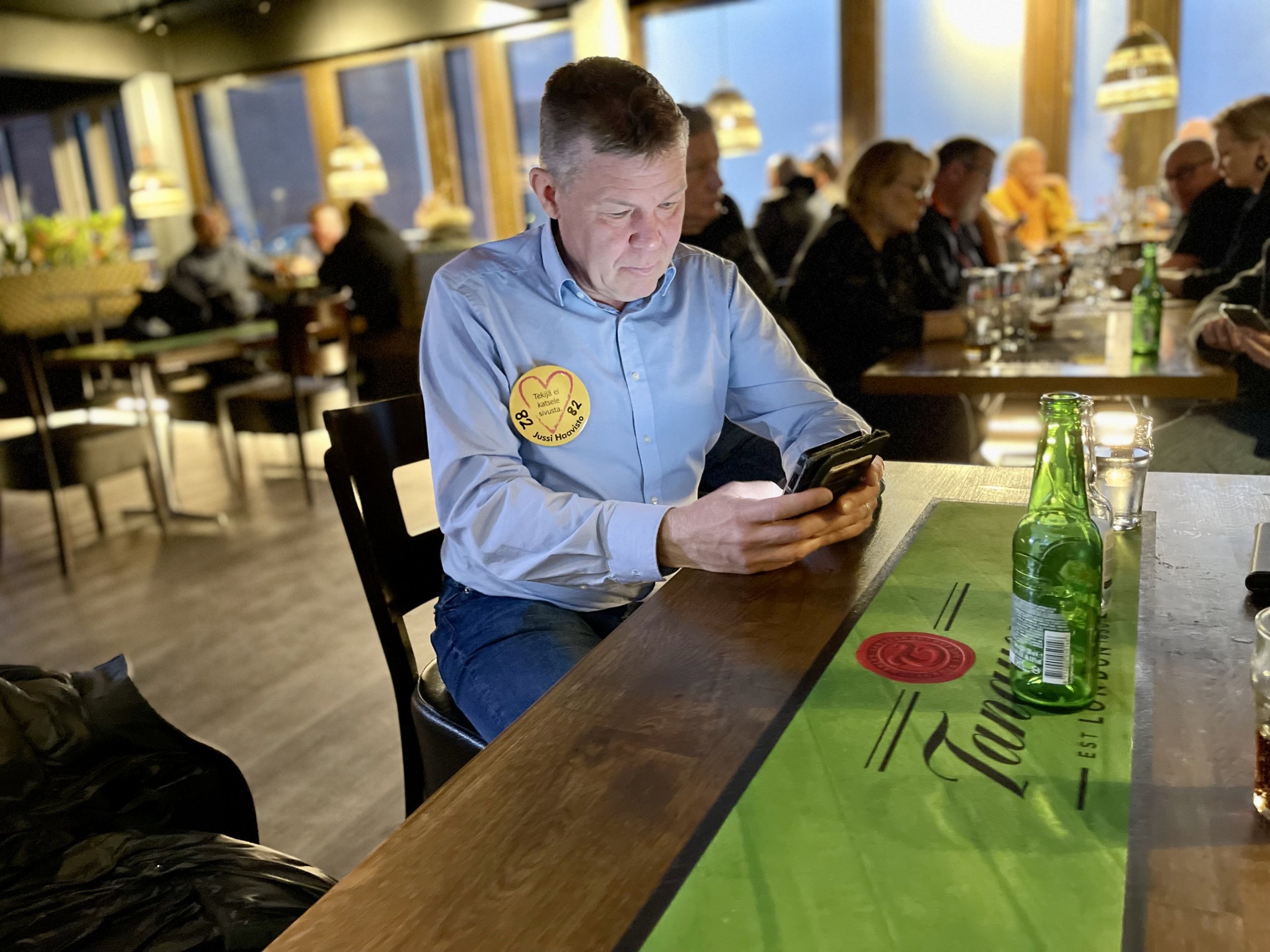 Jussi Haavisto katsoo äänestystilannetta puhelimensa näytöltä.