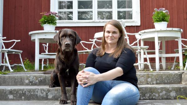 Jessica vonWendt istuu koiransa kanssa Toosilan kartanon pääsisäänkäynnin...