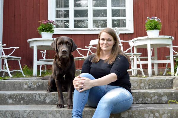 Jessica vonWendt istuu koiransa kanssa Toosilan kartanon pääsisäänkäynnin...