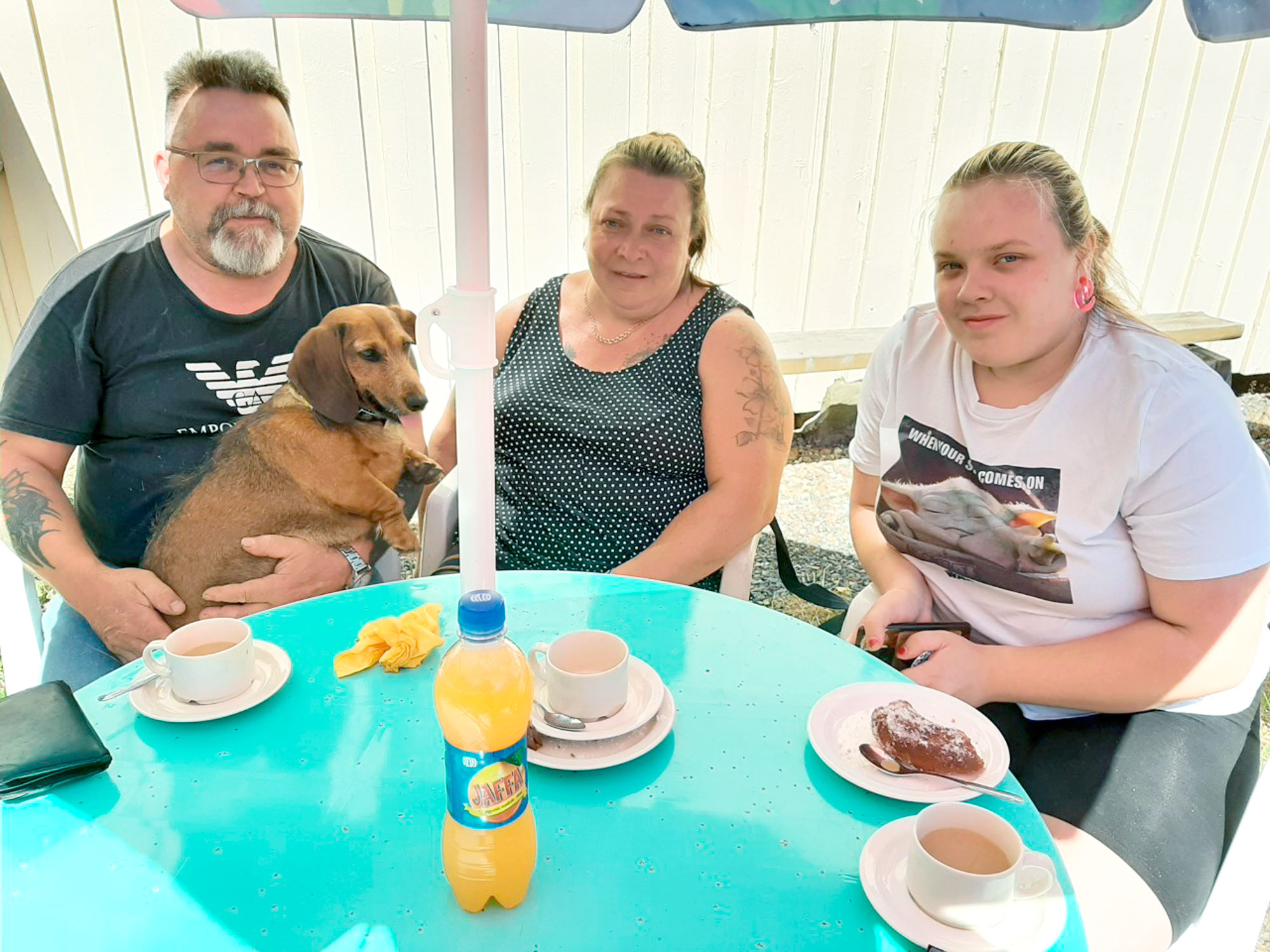 Karkeakarvainen mäyräkoira Cindy pääsi mukaan Erkki, Nina ja Johanna Rainion kahvitteluretkelle, joka suuntautui Vehkajärven Nuorisoseuran kesäkahvilaan.