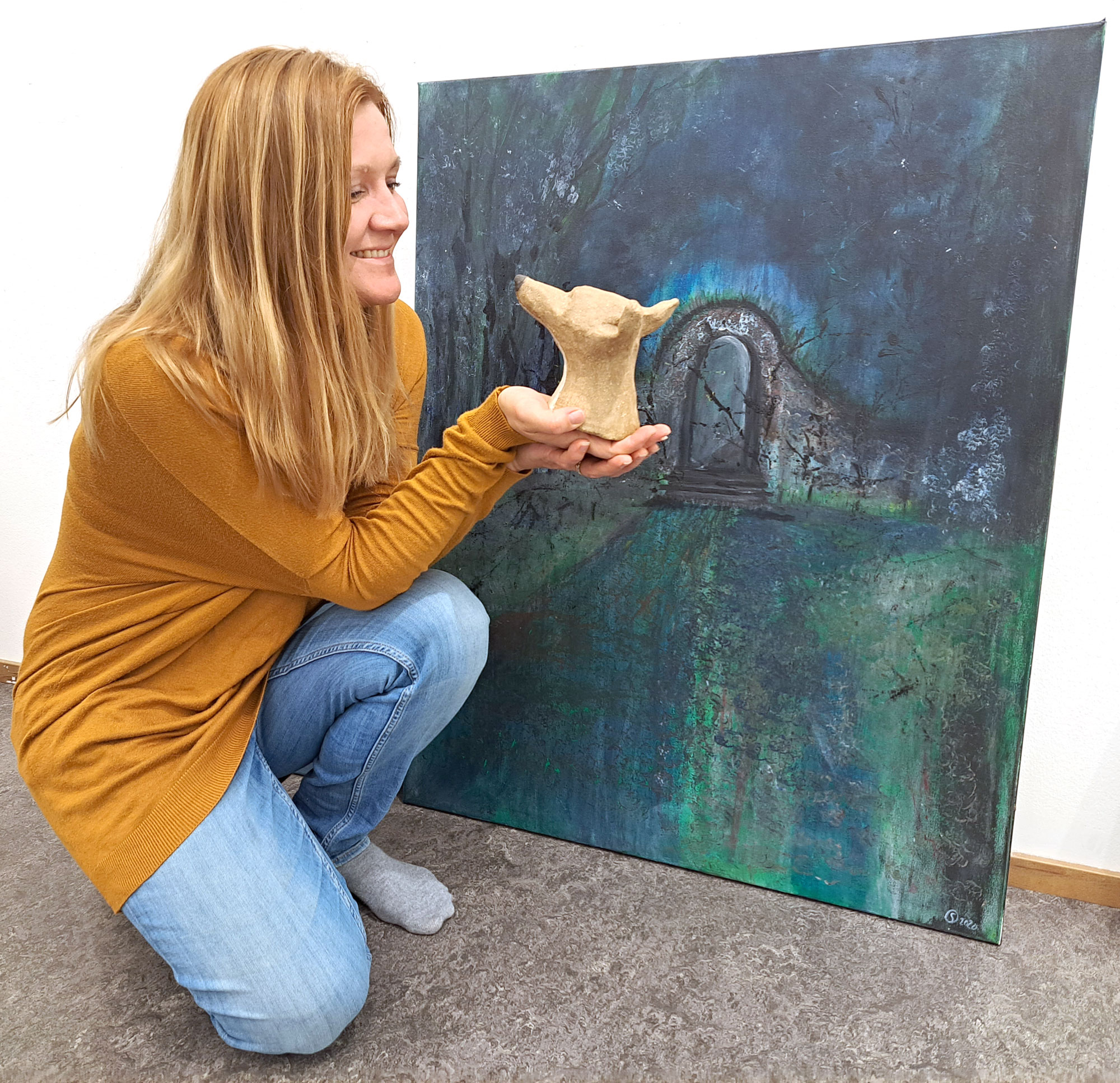 Sinisen metsän lohtu -näyttely koostuu Sari Orpanan teoksista, joissa hän on hyödyntänyt erilaisia itseään kiinnostavia materiaaleja ja tekniikoita. Taustalla teos nimeltään Siirtymä.